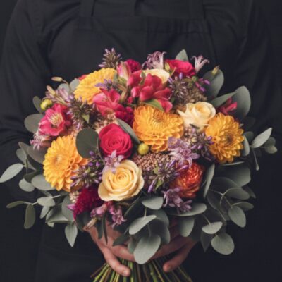 Bouquet "Éclat Vitaminé" ​L'Esprit de la Création ​Une explosion de couleurs et de vitalité ! Ce bouquet rond est une ode à la joie, mêlant harmonieusement des teintes orange tonique, rose fuchsia vibrant et crème délicat. Sa structure foisonnante et ses touches de petites fleurettes apportent une légèreté aérienne, idéale pour illuminer une journée ou célébrer un moment festif avec élégance. ​Détails de la Composition ​Parce que nous privilégions la fraîcheur absolue, la composition de ce bouquet évolue au fil des saisons et des récoltes dans notre jardin de Roncq : ​Fleurs de Saison : Une sélection variable de fleurs nobles (roses, dahlias, gerberas ou fleurs champêtres selon l'arrivage) déclinées dans notre palette signature orange, crème et fuchsia. ​Notes de Légèreté : Accompagné de délicates petites fleurettes pour un effet vaporeux et naturel. ​Le Feuillage : Un écrin généreux de feuillage d'eucalyptus, dont les reflets bleutés subliment les couleurs vives et diffusent un parfum frais et apaisant.